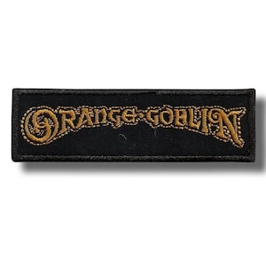 Può includere: Toppa rettangolare nera con la scritta "ORANGE GOBLIN" ricamata in filo dorato. Il testo è in un carattere stilizzato con decorazioni. La toppa ha un bordo nero ed è destinata all'abbigliamento o agli accessori.