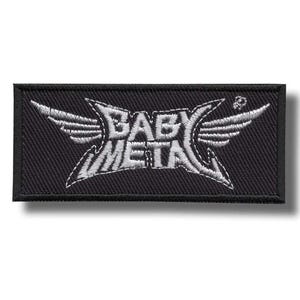 May include: Black rectangular patch featuring the white text "BABY METAL" with wing-like designs on either side. The patch has a black border and a shadow.