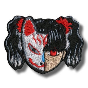 May include: Embroidered patch featuring a split design: one half is a white and red Kitsune mask, the other half is a girl with black hair and a red eye. The patch has a black border and is likely for clothing or accessories.