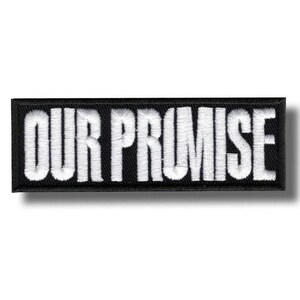May include: Black rectangular patch with the embroidered text "OUR PROMISE" in white. The patch has a black border and a shadow effect, creating a 3D appearance. The text is in a bold, sans-serif font.