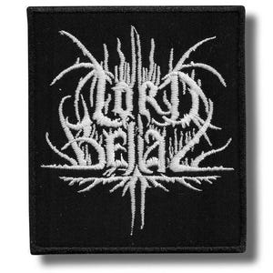 May include: Black square patch with white embroidered text that reads "LORD BELIAL" in a gothic font. The design features intricate, spiky, and stylized elements. The patch is likely for clothing or accessories.