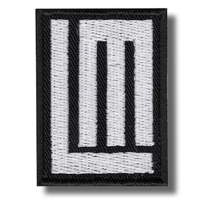 Puede incluir: Parche bordado rectangular con borde negro y diseño "LM" blanco. Las letras son líneas verticales gruesas, creando una apariencia gráfica audaz. El parche está diseñado para su aplicación en ropa o accesorios.