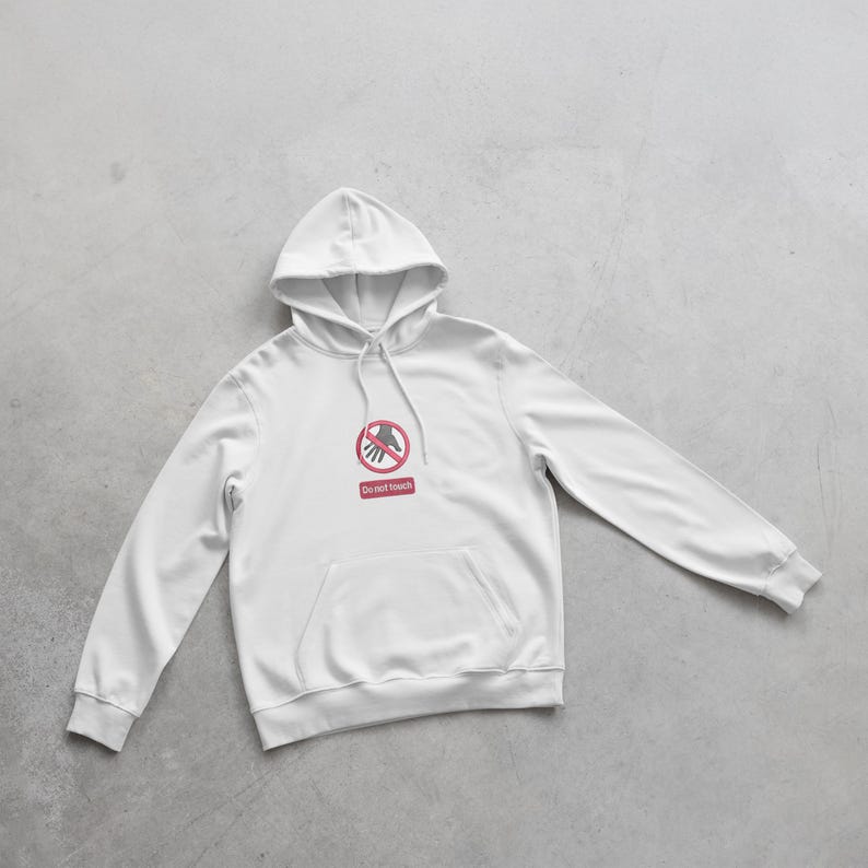 Peut inclure: Sweat &agrave; capuche blanc avec une poche avant et une capuche &agrave; cordon. Le sweat-shirt pr&eacute;sente un graphisme rouge et blanc d'une main avec un symbole de cercle et de barre rouge, et les mots "Do not touch" en dessous.