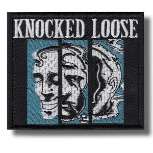 May include: Embroidered patch featuring the text "KNOCKED LOOSE" in white above a blue panel with two stylized faces behind bars. The patch has a black border.