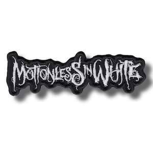 以下が含まれることがあります： 黒と白の刺繍パッチ。バンド名「Motionless In White」がゴシック様式でデザインされています。黒い背景に白い渦巻きフォントを使用。パッチには黒い縁取りがあります。