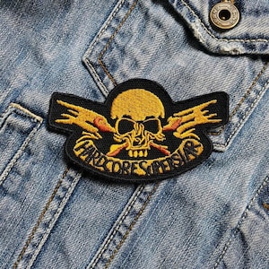 May include: Embroidered patch with a yellow skull, orange flames, and the text "HARDCORE SUPERSTARS" on a black background. The patch is attached to a blue denim jacket.