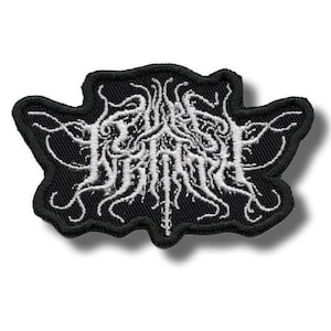 May include: Black embroidered patch with a white, intricate design. The patch features a complex, swirling pattern with a central text element. The edges are neatly stitched, creating a defined border. This patch is suitable for jackets, bags, or other fabric items.