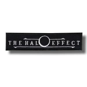May include: A black rectangular patch with white embroidered text reading "THE HALO EFFECT". The design features a white circle and lines. This patch is likely for clothing or accessories.