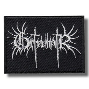 以下が含まれることがあります： 白の刺繍テキストと画像が施された黒い長方形のパッチ。テキストはバンド名で、2本の剣と翼のようなデザインが特徴です。このパッチは、ジャケットやバッグ用です。