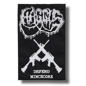 Puede incluir: Parche rectangular negro con texto y gráficos bordados en blanco. La parte superior presenta la palabra "FAGGUS" en una fuente goteante. Debajo hay dos rifles cruzados, con las palabras "DEFEND MINCECORE" debajo.