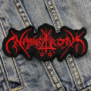 Puede incluir: Parche negro bordado con letras y símbolos góticos rojos. El parche está sobre un fondo de mezclilla. El diseño presenta texto estilizado y elementos decorativos, adecuado para chaquetas o bolsos.