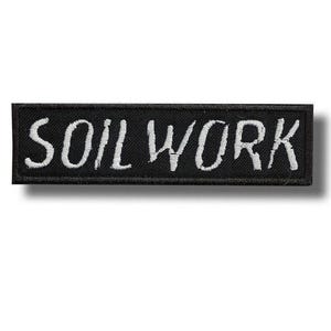 Könnte beinhalten: Schwarzer rechteckiger Aufnäher mit dem weiß gestickten Text "SOIL WORK". Der Aufnäher hat einen schwarzen Rand und ist wahrscheinlich aus Stoff. Der Text ist im Handschriftstil.