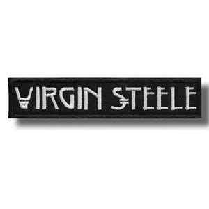 May include: A rectangular black embroidered patch with the white text "VIRGIN STEELE". The text is in a stylized font. The patch has a black border and is likely designed to be sewn onto clothing or accessories.