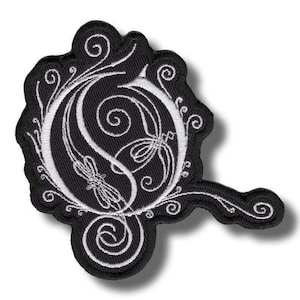 以下が含まれることがあります： 黒と白の刺繍パッチ。装飾的な文字「O」と花柄が特徴です。 パッチは、曲がった延長部を備えた独特の形状をしており、衣類やアクセサリーのカスタマイズに最適です。