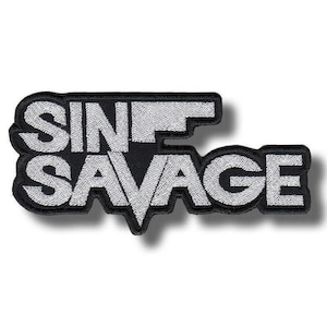 May include: Black and white embroidered patch with the words "SIN SAVAGE". The text is in a bold, stylized font, with the letters in white against a black background. The patch has a black border.