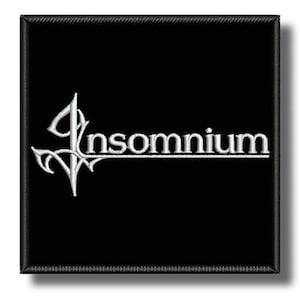 Puede incluir: Parche cuadrado negro con la palabra "Insomnium" bordada en blanco. El texto está estilizado con un adorno decorativo en el lado izquierdo. El parche tiene un borde negro.