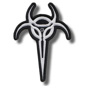 Könnte beinhalten: Schwarz-weißer, gestickter Aufnäher mit einem symmetrischen Design. Der Aufnäher hat ein zentrales kreisförmiges Element mit gebogenen Hörnern und einer spitzen Basis. Das Design ist schwarz umrandet und mit weißen Nähten versehen.