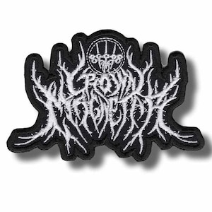 Op de afbeelding: Zwart en wit geborduurde patch met de tekst "CROWN MAGNETAR" in een gestileerd, gotisch lettertype. De patch heeft een unieke, onregelmatige vorm met een gedetailleerd, getextureerd ontwerp en een cirkelvormig embleem bovenaan.