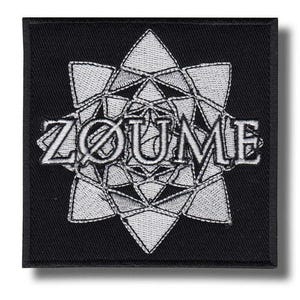 Può includere: Toppa quadrata nera con design geometrico ricamato bianco e la parola "ZØUME". Il design è una forma stilizzata a stella o fiore. La toppa ha un bordo nero.