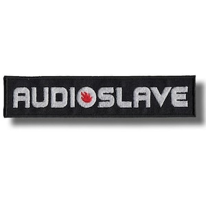 Może przedstawiać: Czarna, prostokątna, haftowana naszywka z napisem "AUDIOSLAVE" w kolorze białym. Czerwony płomień umieszczony jest pomiędzy słowami. Przeznaczona na odzież lub akcesoria.