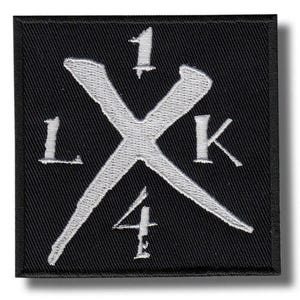 Puede incluir: Parche cuadrado negro con diseño bordado blanco. El diseño presenta una gran "X" blanca con los números "1" y "4" y las letras "L" y "K" en cada esquina. El parche tiene un borde negro y una sombra.