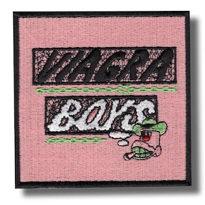 Op de afbeelding: Geborduurde patch met de tekst "VIAGRA BOYS" in zwart en wit op een roze achtergrond. Een cartoonfiguur met een cowboyhoed en sigaret is afgebeeld. De patch heeft een zwarte rand.