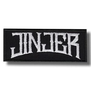 Könnte beinhalten: Schwarzer rechteckiger Aufnäher mit dem Wort "JINJER" in weißer, stilisierter, gotischer Schrift gestickt. Der Aufnäher hat einen schwarzen Rand und ist wahrscheinlich zum Aufnähen oder Aufbügeln auf Kleidung oder Accessoires gedacht.