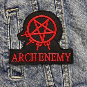 May include: Black patch featuring a red pentagram design and the word "ARCHENEMY" embroidered in red. The patch is attached to a denim jacket, creating a striking, gothic look.