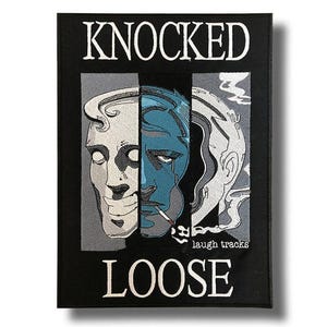 Peut inclure: Écusson rectangulaire noir avec les mots "KNOCKED LOOSE" en lettres blanches. L'écusson présente un graphique d'un visage divisé en trois sections verticales, avec un visage bleu au centre et une cigarette à la bouche. Les mots "laugh tracks" sont également visibles.