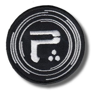 Könnte beinhalten: Ein runder, schwarzer Aufnäher mit einem weißen Stickdesign. Das Design zeigt einen stilisierten weißen Buchstaben "P" in weißen konzentrischen Kreisen. Drei kleine weiße Punkte befinden sich unter dem Buchstaben.