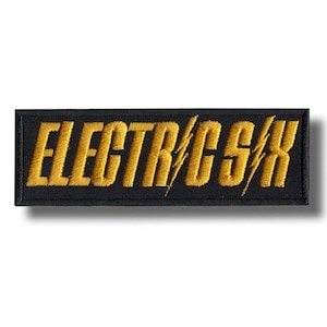 Könnte beinhalten: Gestickter Aufnäher mit dem Text "ELECTRIC CSX" in goldfarbenem Garn auf schwarzem Hintergrund. Der Text enthält ein Blitz-Design. Der Aufnäher ist rechteckig und hat einen schwarzen Rand.