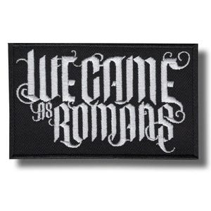Könnte beinhalten: Schwarzer rechteckiger Aufnäher mit weiß gesticktem Schriftzug "We Came As Romans" in gotischer Schrift. Der Aufnäher hat einen schwarzen Rand und ist für Kleidung oder Accessoires bestimmt.