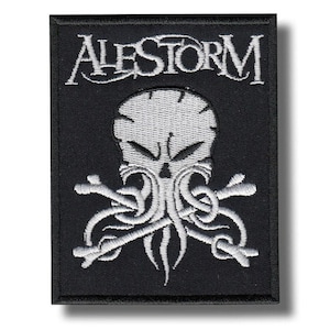 Könnte beinhalten: Schwarz gestickter Aufnäher mit dem Wort "ALESTORM" über einem weißen Totenkopf mit Tentakeln und gekreuzten Knochen. Der Aufnäher ist rechteckig und hat einen schwarzen Rand.