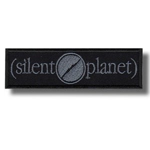 May include: A white ceramic mug with a black handle and the text "But First, Coffee" in a bold, black font. The mug is filled with a dark liquid, likely coffee, and sits on a light-colored surface.