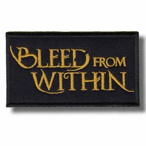 Op de afbeelding: Een rechthoekige zwarte patch met goudkleurige geborduurde tekst "BLEED FROM WITHIN". De patch heeft een getextureerd uiterlijk en een subtiele schaduw.