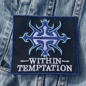 Puede incluir: Un parche rectangular con fondo negro y borde azul. El parche presenta un emblema azul y blanco y las palabras "WITHIN - TEMPTATION" en blanco.