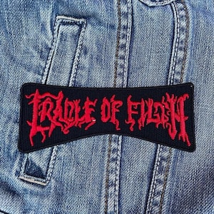 Op de afbeelding: Een witte keramische mok met een zwart handvat en de tekst "But First, Coffee" in een zwarte, handgeschreven lettertype. De mok staat op een wit oppervlak.