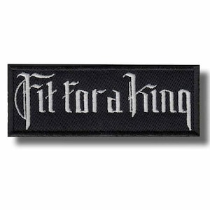 May include: Black rectangular patch with the embroidered text "Fit for a King" in a gothic font. The text is in white thread, and the patch has a black border.