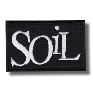 Könnte beinhalten: Schwarzer rechteckiger Aufnäher mit dem Wort "SOiL" in Weiß gestickt. Der Aufnäher hat einen schwarzen Rand und ist wahrscheinlich aus Stoff. Die Buchstaben sind in einer stilisierten Schriftart.