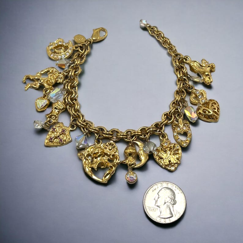 May include: Gold charm bracelet with a variety of charms, including hearts, a crescent moon, a flower, and a unicorn. The bracelet is about the size of a quarter.