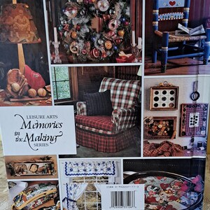 以下が含まれることがあります： 「Memories in the Making」というタイトルの書籍の表紙で、家の装飾プロジェクトの画像がいくつか掲載されています。プロジェクトには、リース、椅子、ランプ、電話、トレイ、壁の装飾が含まれています。この書籍の表紙は、レジャーアートシリーズからのものです。