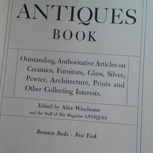 May include: The cover of a book titled "The Antiques Book" with the subtitle "Outstanding, Authoritative Articles on Ceramics, Furniture, Glass, Silver, Pewter, Architecture, Prints and Other Collecting Interests."  The book is edited by Alice Winchester and the staff of The Magazine ANTIQUES.  The book is published by Bonanza Books in New York.