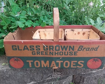 May include: A vintage cardboard box with a wooden handle, labeled "Glass Grown Brand Greenhouse Tomatoes". The box has two smaller wooden baskets inside, and the label features a red tomato graphic.
