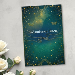 May include: A rectangular print featuring a dark teal and green gradient background with a starry night sky effect. The text "The universe knew." is centered above a gold line-art illustration of two hands reaching toward each other.