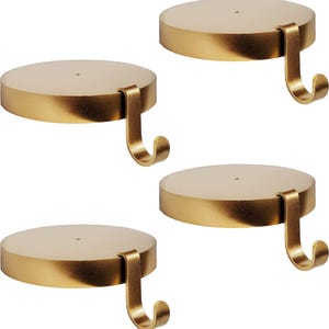 May include: Four gold-colored, circular candle holders with attached hooks. The holders have a flat, disc-shaped top and a curved hook extending from the side. The overall design is simple and elegant, suitable for various decor styles.