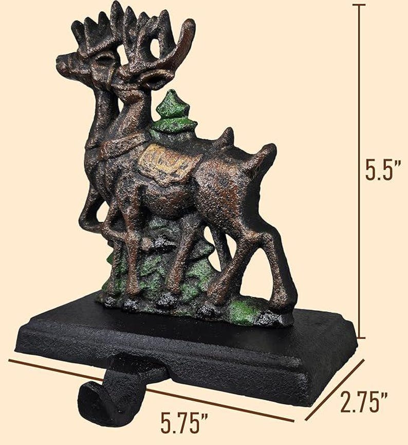 May include: A cast iron Christmas stocking holder featuring two reindeer with large antlers, a small green tree, and a black base. The holder is 5.75 inches long, 5.5 inches high, and 2.75 inches wide. The reindeer are brown with green accents.