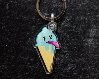 May include: A blue and yellow ice cream cone keyring with a pink tongue sticking out and the text "@trash_jeff" on the bottom.