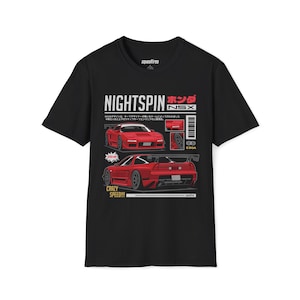 Pode incluir: Camiseta preta com um gráfico de carro vermelho, o texto "NIGHTSPIN" e "NSX". O design inclui as palavras "CRAZY SPEED!!!" e texto japonês. A camiseta tem gola redonda e mangas curtas.