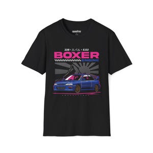May include: Black t-shirt featuring a blue sports car graphic with the word "BOXER" in pink and the word "ENGINE" in blue. The design includes Japanese text and a mountain and sun graphic.