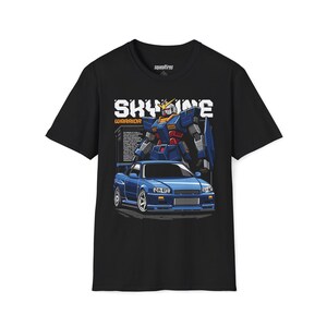 May include: Black t-shirt featuring a blue sports car and a robot graphic. The text "SKYLINE WARRIOR" is above the car and robot. The robot is blue, red, and yellow. The car is blue.